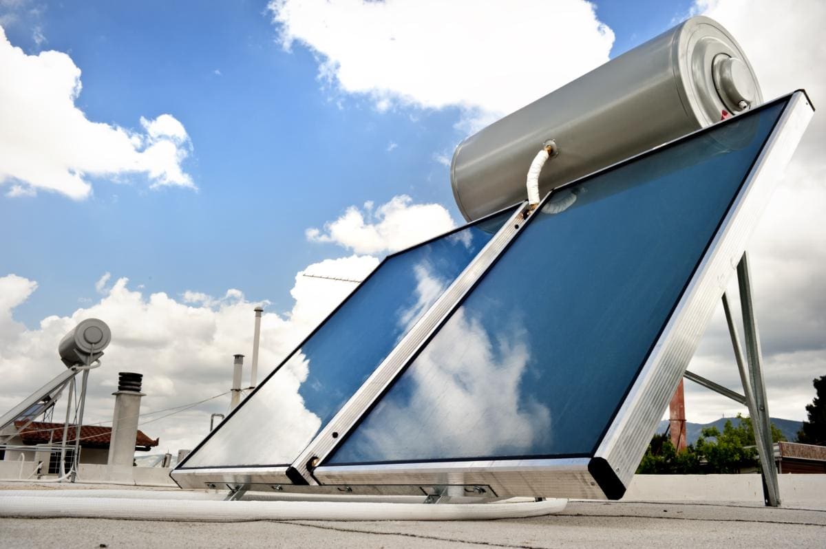 A solar water heating system standing tall beneath a blue sky