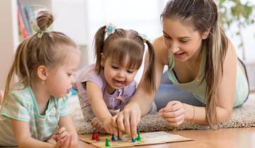 Mother,And,Kids,Daughters,Sitting,In,A,Playroom,,Playing,A