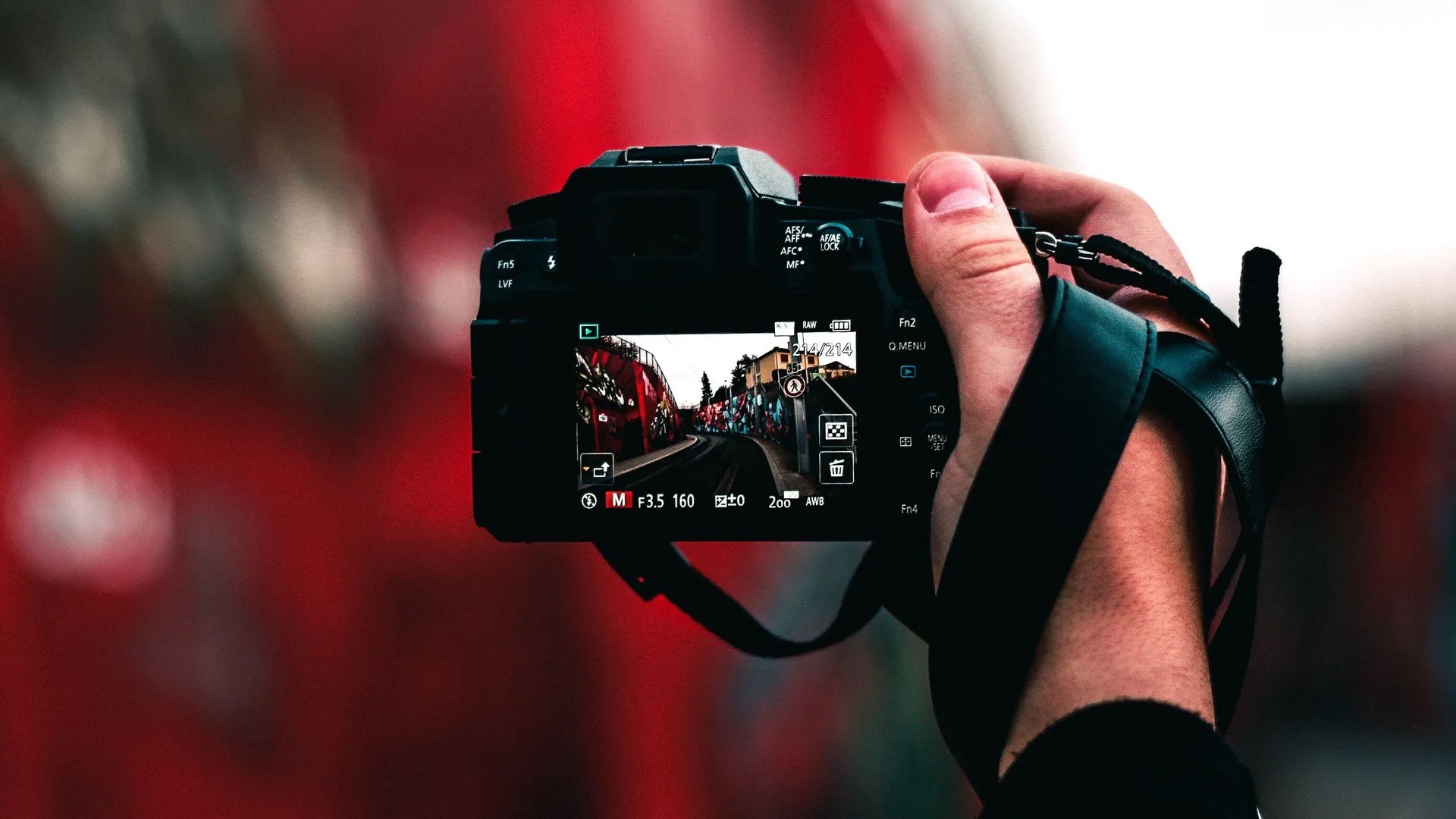 A hand holding a digital camera