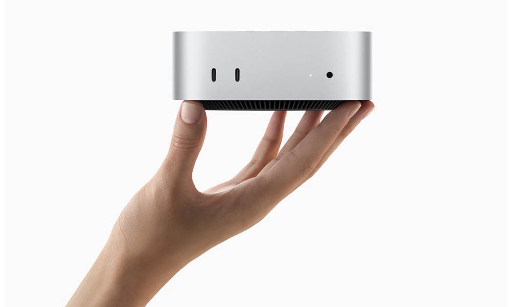 A hand holding a Mac Mini 