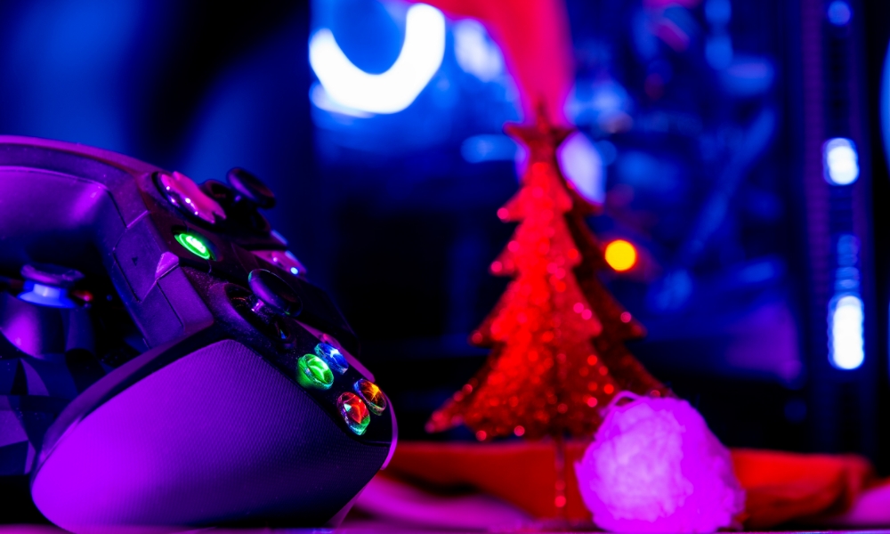 Α controller in front of a Christmas tree in neon colors