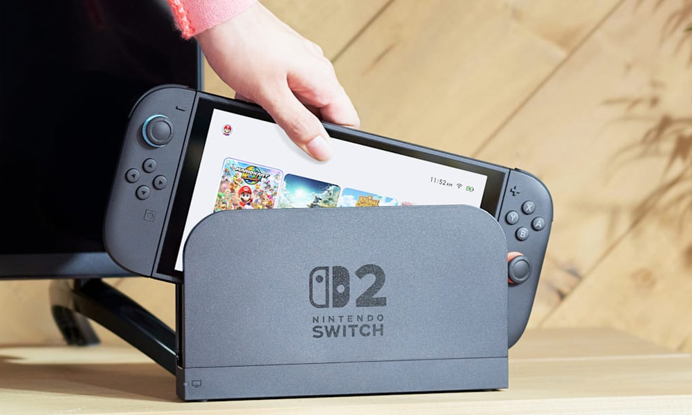 A hand lifting a Nintendo Switch 2 off its dock