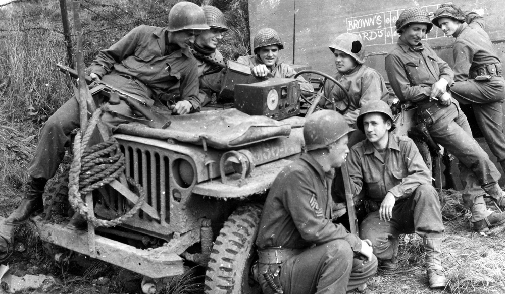 WWII U.S. Soldiers Listen to Jeep's Radio on Beachhead, south of Rome