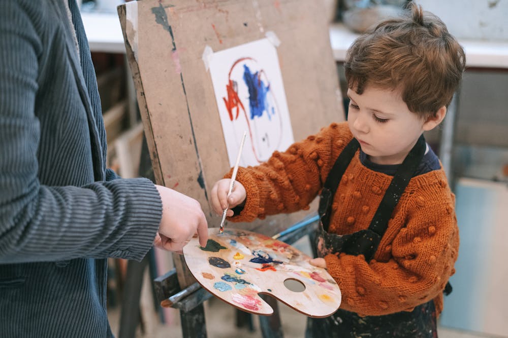 kid drawing with adult supervision
