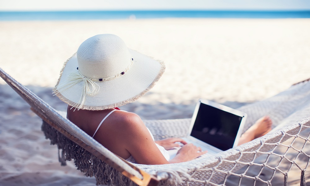 woman at the beach with laptop