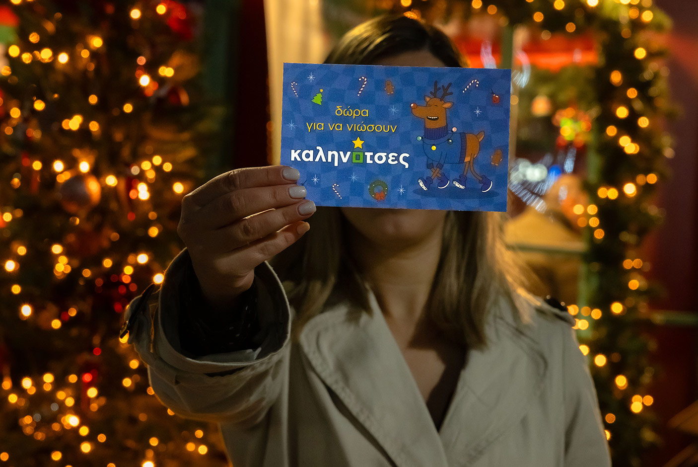 Girl holding a card that reads "Gifts to feel kalinotses" 