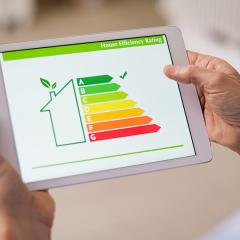 A tablet being held, showing the color-coded energy efficiency scale with a tick on A