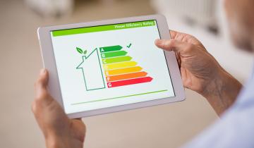 A tablet being held, showing the color-coded energy efficiency scale with a tick on A