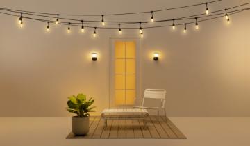 A bench, a door and a succulent inf front of a door with twinkle lights hanging from above