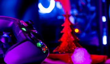 Α controller in front of a Christmas tree in neon colors