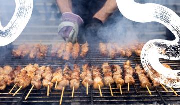 A grill full of skewered meat already sizzling. 