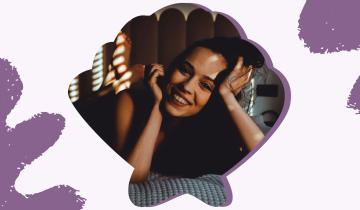 A photo of a girl smiling. The frame looks like a sea shell. 
